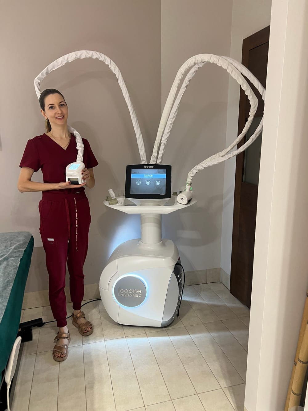 Kosmetolog Agnieszka Wojtczak stoi obok urządzenia do endermologii ICOONE LASER MED 2 w gabinecie Poziomkowego Spa przy Al. Wilanowskiej 89 w Warszawie, trzymając głowicę zabiegową